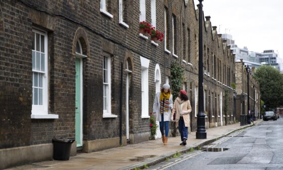 Two women walking along a residential street lined with brick houses in Aylesbury, showcasing an affordable and typical Buckinghamshire neighbourhood.
