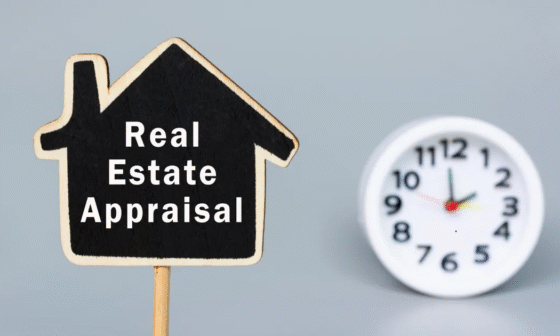 Wooden house-shaped sign with the words “Real Estate Appraisal” next to a clock, symbolizing property evaluation and timing in home buying.